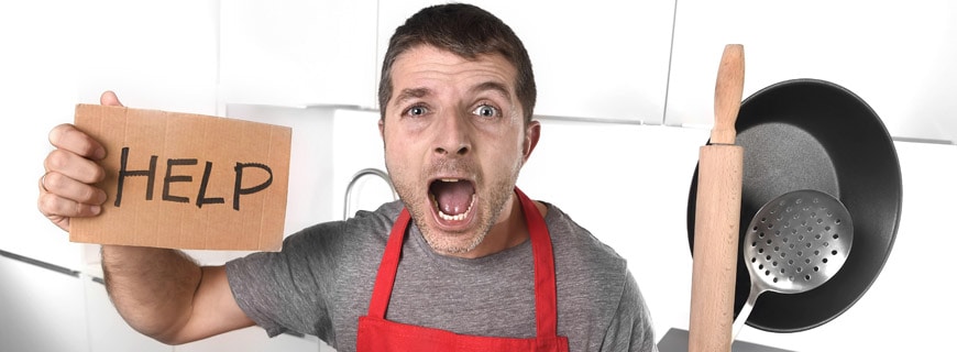küchenchef mit HELP-Schild in der Hand
