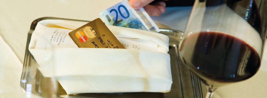 Tipps für Tip eine Kreditkarte und ein Geldschein liegen auf dem Tisch im Restaurant