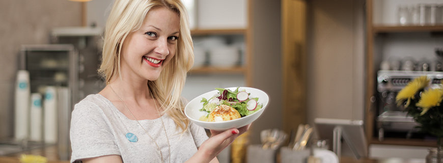 eine Dame präsentiert eine Portion Knödel