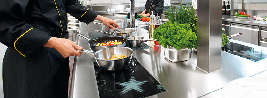 Menu System ein Koch am Herd, verfügend über modernste Induktionstechnik