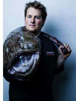 Roland Huber mit einem Riesenmaulfisch über der Schulter 