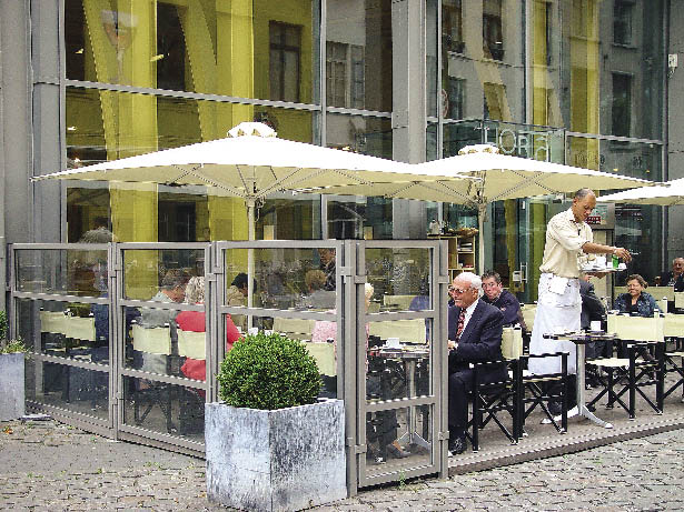 Im Gastgarten eines Lokals werden Gäste bedient 