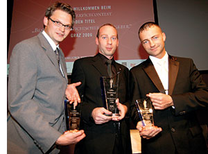 drei Maenner mit Preisen in der Hand 