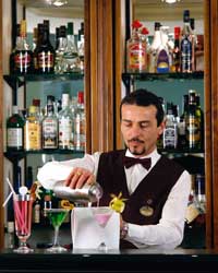 Arbeiten auf Malta Ein Barkeeper steht hinter der Bar und mixt gerade einen Cocktail