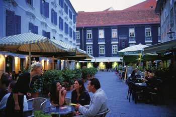 ein Innenhof mit puchsbäumchen und bistro tischen 