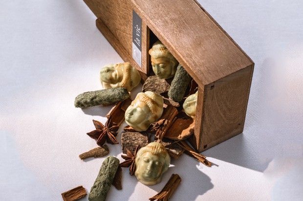 Buddhapralinen und petite four in einer Holzschachtel