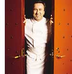 Daniel Boulud in Kochuniform zwischen den Fluegeln einer Tuer 