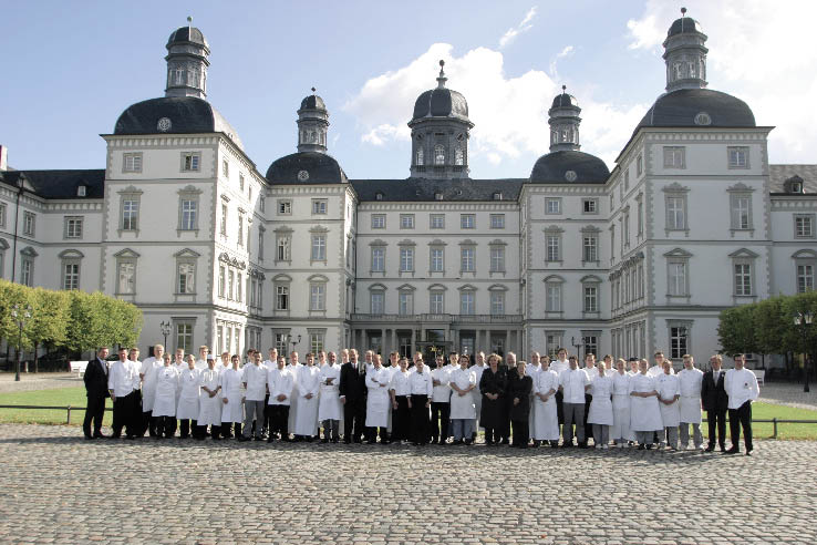 Das Hotel Versailles im Hintergrund und davor ein Team der Spitzenküche 