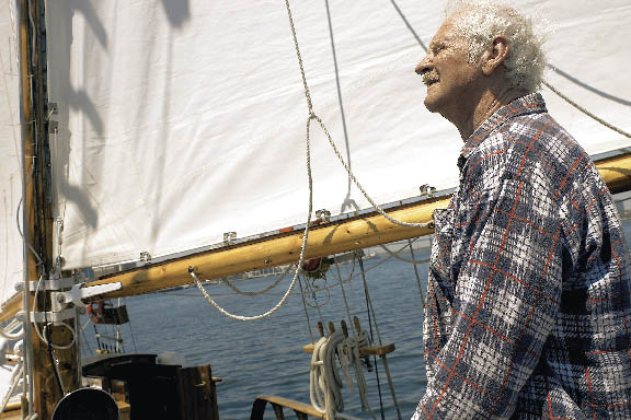 ein Herr im karierten Hemd auf einem Segelschiff 