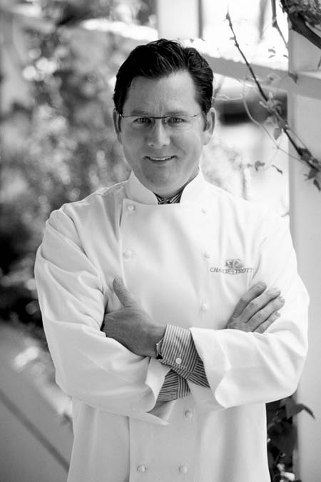 Charlie Trotter in weißer Kochjacke mit einer Brille, verschraenkten Armen und in die kamera leachelnd 