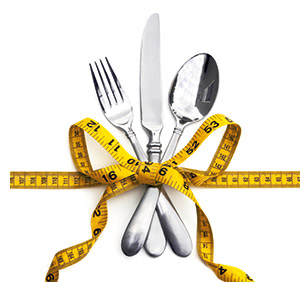 Messer, Gabel und Löffel mit einem Massband zu einem Mascherl gebunden 