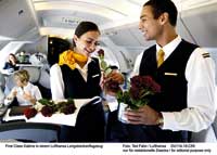 zwei Stewards an Board eines Flugzeuges mit roten Rosen