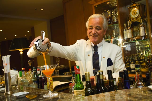 unterschiedlichen Aperitifs ein Barkeeper füllt den Cocktail vom Shaker ins Glas