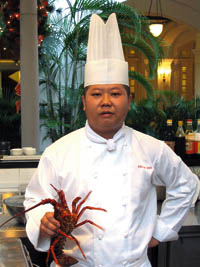 Soh Ching Choon, ein Koch mit weißer Kochjacke und Hummer in der Hand 