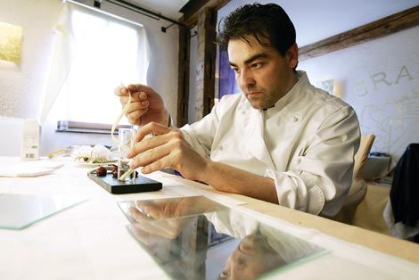 Juan Amador sitzt an einem Tisch und legt den Feinschliff an seiner Kreation an 
