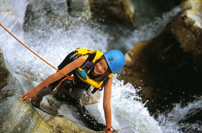 eine junge Frau betreibt Canyoning 