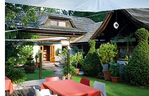 ein kleines gemuetliches Landhaus und dessen Gastgarten mit viel Gruen