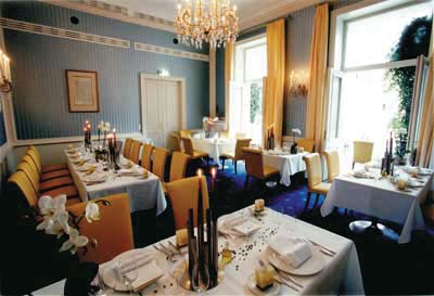ein Restaurant mit himmelblauen wänden und sonnengelben stoffsesseln 