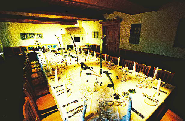 eine lange prachtvoll gedeckte Tafel im Restaurant Zur Blauen Gans
