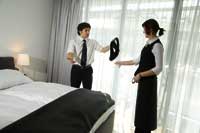eine Frau und ein Mann,Personal des Hotels stehen im Hotelzimmer und scheinen eine Auseinandersetzung zu haben 