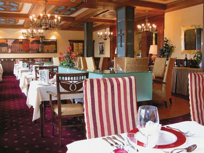 einblick in ein restaurant mit weißen tischtüchern und einem rotweiss liniertem stuhl