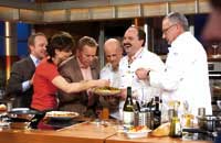 eine Gruppe von TV-Köchen bestaunen ein Gericht 
