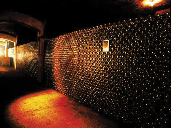 eine in rotes licht getauchte wand befüllt mit flaschen 