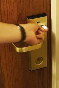 eine Hand öffnet mit der Karte das Hotelzimmer