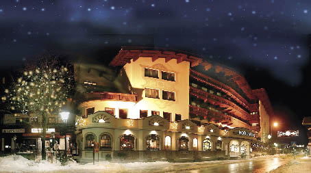 gewölbtes Gebäude in Gelb und beleutet und einem Sternenhimmel im Winter