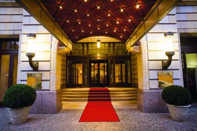 der eingang eines noblen Hotels mit einem langen roten teppich 