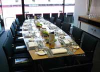 ein Meetingraum, eine lange Tafel ist gedeckt 