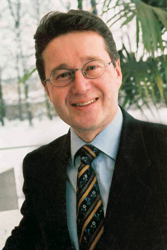 Direktor Heffeter Mann mit Anzug und Brille lächenlnd