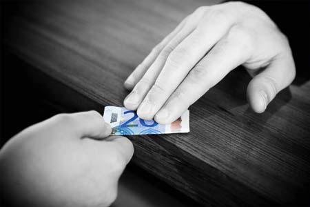 ein schwarzweisses bild, zwei haende die an endgegengesetzten enden einen zwanzig euro schein halten 