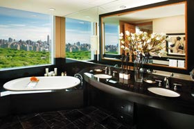 Luxusbad ein Einblick in ein Luxusbad, unter dem großen Fenster mit Blick auf den New Yorker Central Park steht eine Badewanne aus schwarzem Stein