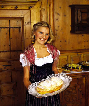 Ein junges Dirndl mit einem Apfelstrudel in der Hand 