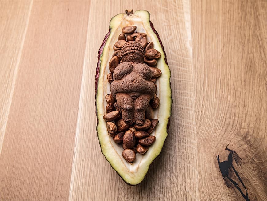 Schoko-Nougat-Mousse in Form der Venus von Willendorf mit Mispelkern-Ganache und eingelegten Mispeln