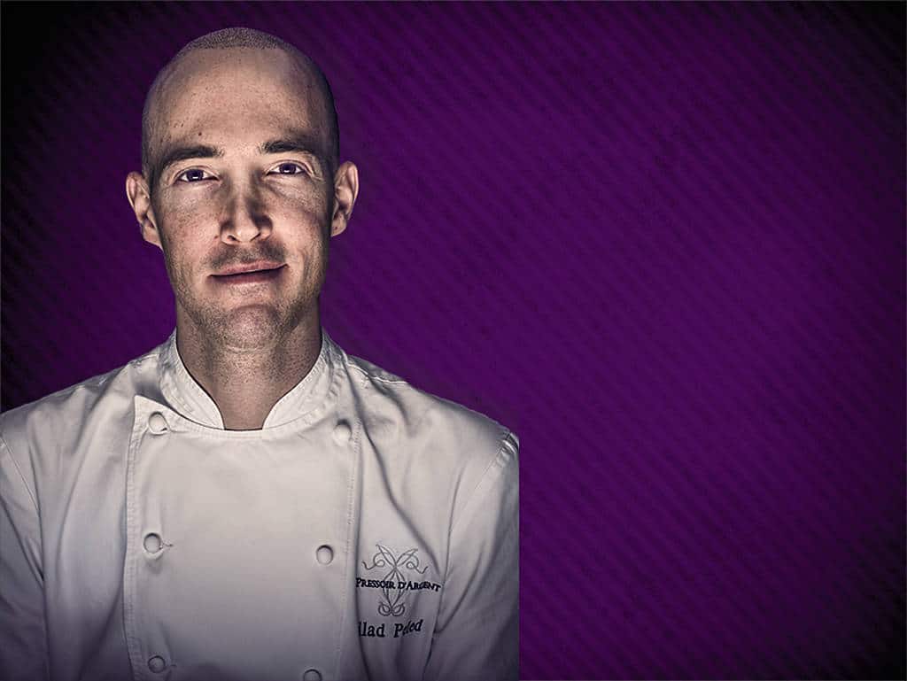 Ein Mann lebt seinen Traum: Gilad Peled wurde die Liebe zum Kochen in die Wiege gelegt. Gilad Peled lächeln, vor violettem Hintergrund