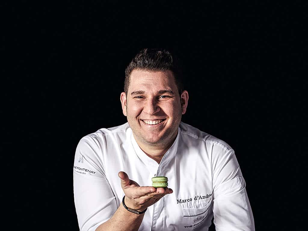 Marco d´Andrea Marco d´Andrea grinst und hält ein Macaron in der Hand