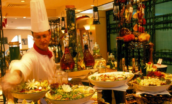 ein Koch befüllt das reichhaltige buffet 