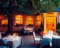 ein kleiner in orangenes licht getauchter gastgarten