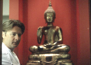 "Chef Extraordinaire" Wini Brugger mit einer Buddha Skulptur im Hintergrund 