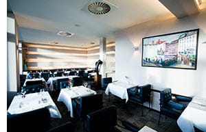 Schwarz-weiss gehaltens Restaurant, weisse eckige tische, schwarze Lederstühle 
