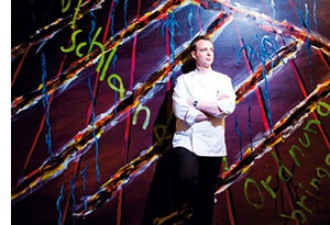 Holger Stromberg angelehnt an eine Graffiti Wand 