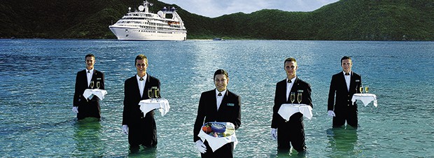 Hochsee Kellner Kellner im Kniehochen Wasser mit Champagner auf Tabletts