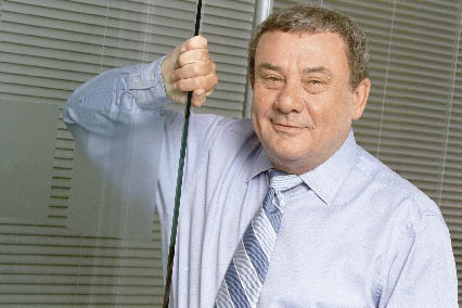 Sol Kerzner hält sich an einer Glastür fest 