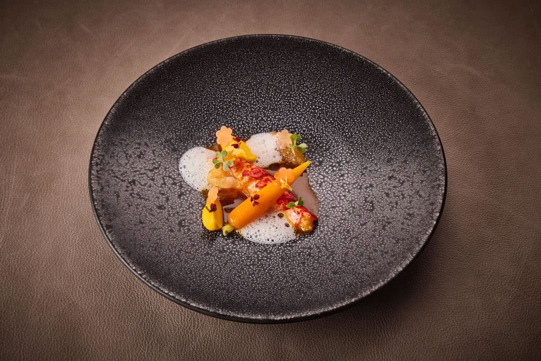 teller-mit-gerichten-hummer-karotte-oxalis-yuzu-timut-pfeffer