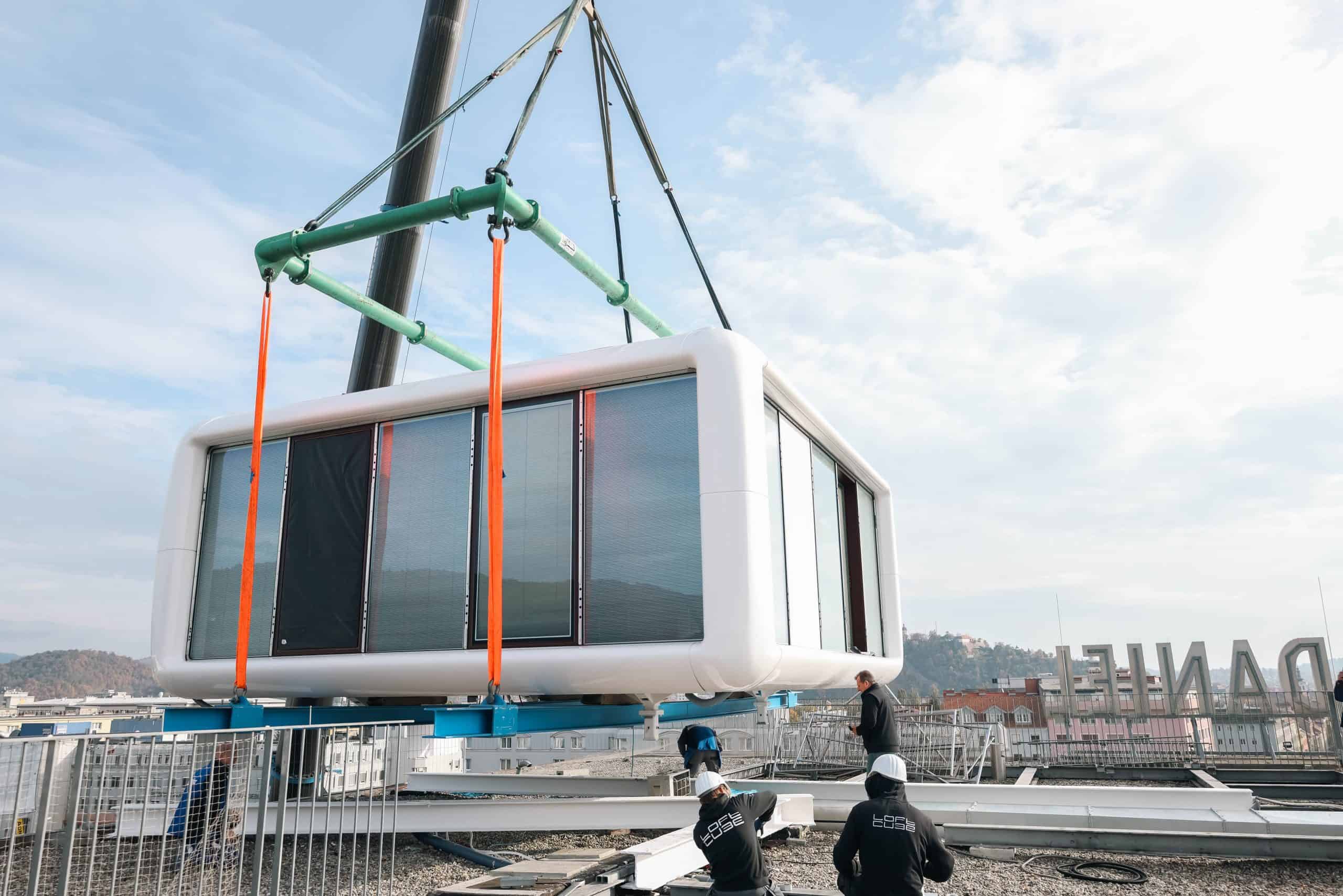 Monteure begleiten das Absetzen des gläsernen LoftCube auf dem Dach des Hotel Daniel Graz.