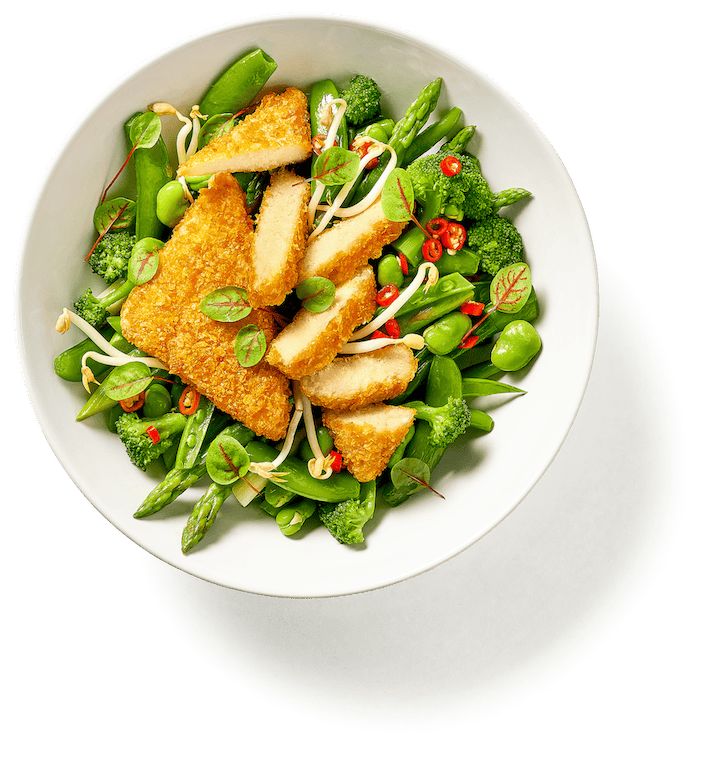 Hilcona Crispy Tofu auf grünem Gemüse mit Brokkoli, Spargel, Sprossen und roten Chiliringen.