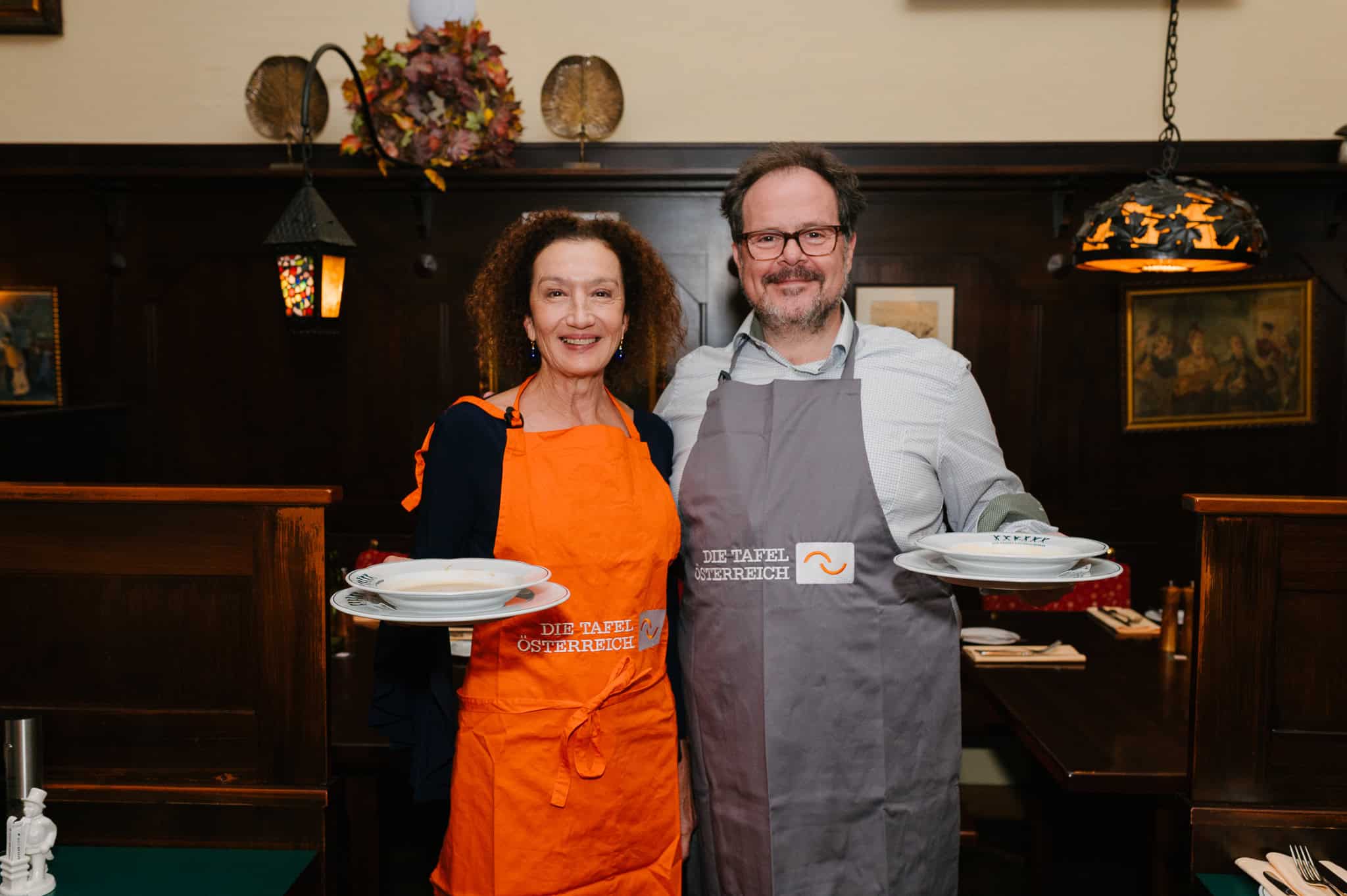 Konstanze Breitebner und Thomas Mraz halten Suppenteller unterstützen Die Tafel Österreich bei der Aktion „Suppe mit Sinn“.